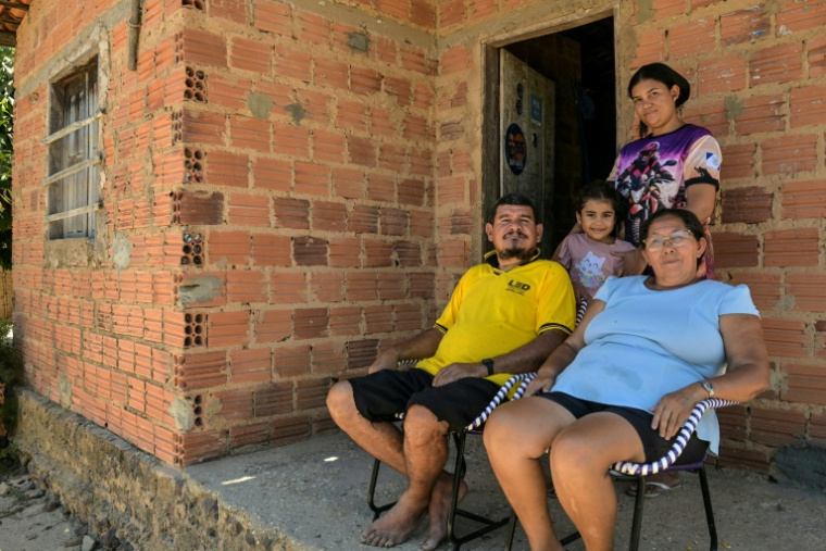 Antonio Carlos Lima Ferreira et son épouse Maria de Fatima Mendes Ferreira avec leur fille et leur petite-fille devant la maison familiale à Vargem Grande, dans l'État du Maranhao, dans le nord-est du Brésil, le 13 octobre 2026 ( AFP / Nelson ALMEIDA )