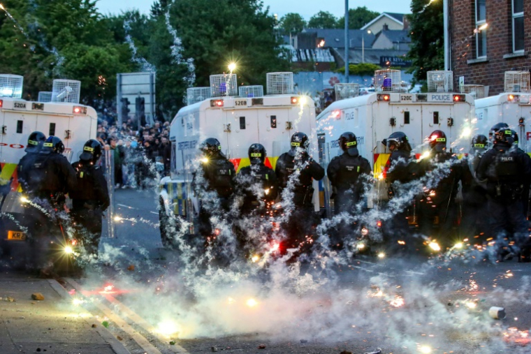 Des feux d'artifice lancés sur la police anti-émeute lors d'une troisième nuit de manifestations visant les immigrés à Ballymena, en Irlande du Nord, le 11 juin 2025 ( AFP / PAUL FAITH )
