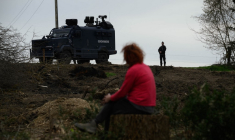 Un manifestant assis devant des policiers tandis que d'autres occupent des arbres pour protester contre le projet d'autoroute A69, à Saix le 22 février 2024. ( AFP / ED JONES )