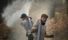 Des volontaires aident les sapeurs-pompiers à Lanton le 29 juillet 2026 ( AFP / Ed JONES )