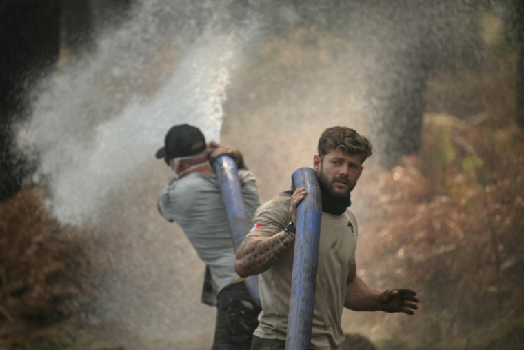 Des volontaires luttent contre le feu dans la forêt de Lanton (Gironde) le 29 juillet 2026 ( AFP / Ed JONES )