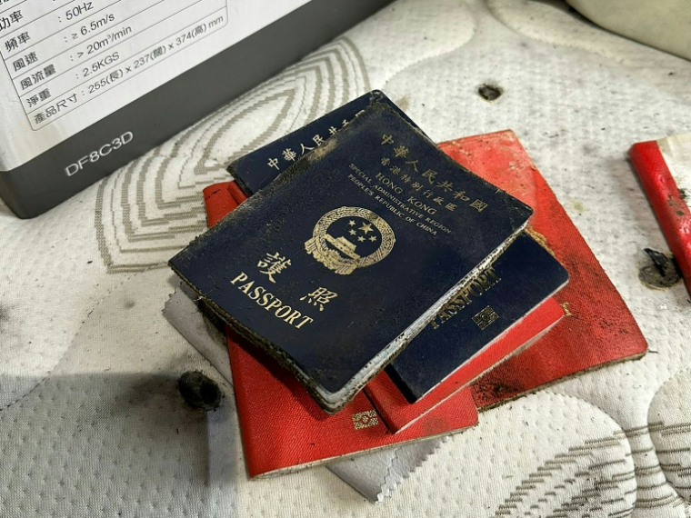 Sur cette photo prise et transmise le 23 avril 2026 par un habitant de Wang Fuk Court, Bowie Chan, des passeports sont empilés dans leur appartement endommagé par l'incendie de novembre, à Hong Kong ( Courtesy of Bowie Chan / Bowie Chan )