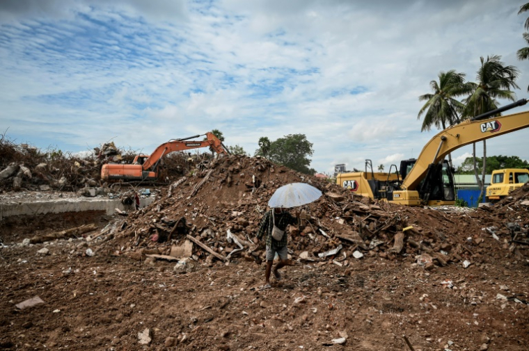Un engin de chantier dégage le site où se trouvait un condominium, détruit lors du tremblement de terre du 28 mars, le 16 septembre 2025 à Mandalay, en Birmanie ( AFP / Sai Aung MAIN )