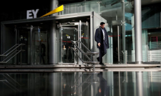 Un homme sortant du siège de la société de comptabilité et de conseil EY
