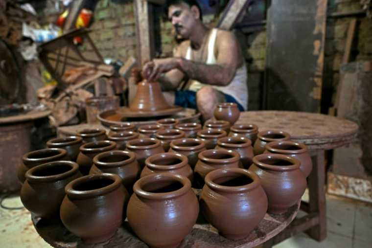 Un potier dans son atelier du bidonville de Dharavi, le 16 juillet 2025 à Bombay, en Inde ( AFP / Indranil MUKHERJEE )