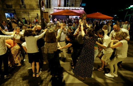 Des personnes dansent dans une rue de Paris pendant la fête de la musique, le 21 juin 2025 ( AFP / Ludovic MARIN )