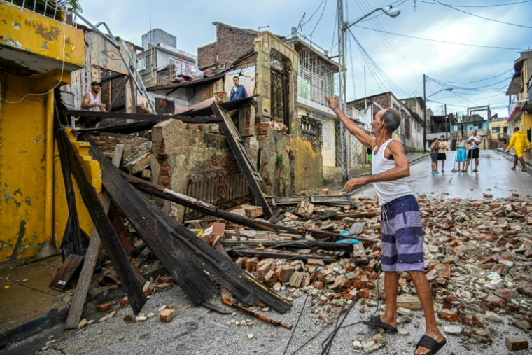 Des habitants devant leurs maisons détruites par le passage de l'ouragan Melissa près de Santiago de Cuba, le 29 octobre 2025, à Cuba ( AFP / YAMIL LAGE )
