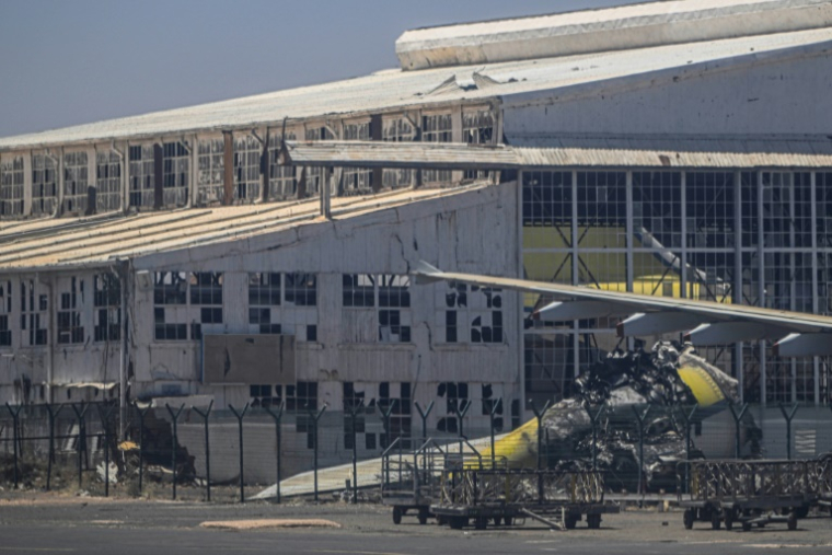 Une partie d'avion endommagée sur le tarmac de l’aéroport de la capitale soudanaise Khartoum, le 15 avril 2026 ( AFP / Khaled DESOUKI )