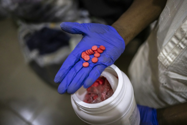 Un agent montre des comprimés rouges de tapentadol dans les locaux de l'Agence nationale de lutte contre la drogue (NDLEA) à Lagos, le 19 février 2026 au Nigeria ( AFP / OLYMPIA DE MAISMONT )
