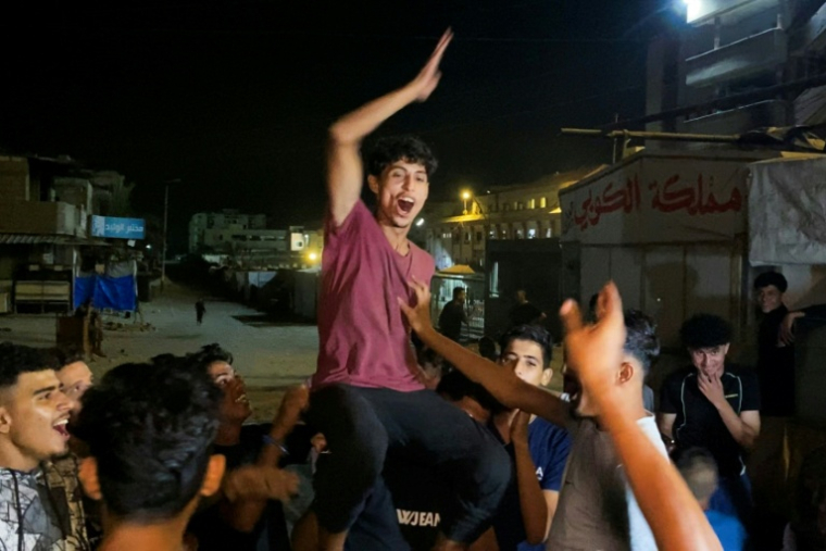 Des Palestiniens célèbrent l'annonce d'un cessez-le-feu entre le Hamas et Israël le 9 October 2025 à Khan Younès, dans la bande de Gaza. ( AFP / - )