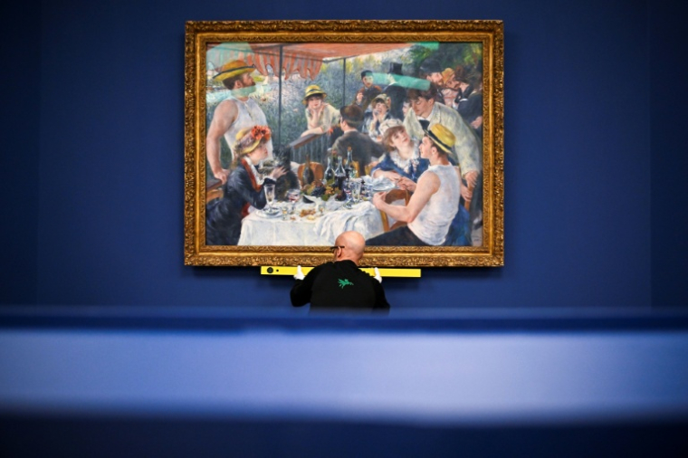 Le tableau "Le Déjeuner des canotiers" du peintre impressionniste Pierre-Auguste Renoir lors de son installation pour l'exposition "Renoir et l'amour : une joyeuse modernité" au musée d'Orsay à Paris, le 2 mars 2026 ( AFP / JULIEN DE ROSA )