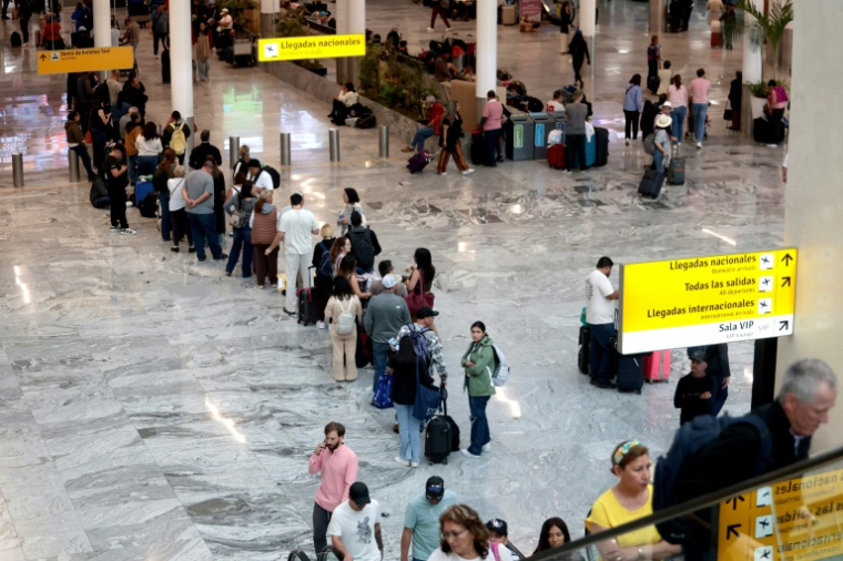 Des passagers attendent dans l'aéroport international de Guadalajara, le 22 février 2026, en raison de l'annulation de vols dus au troubles après la mort du baron de la drogue "El Mencho" ( AFP / Ulises Ruiz )
