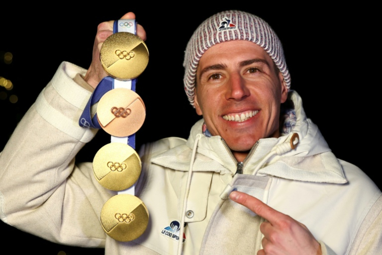 Quentin Fillon Maillet pose avec ses quatre médailles, trois d'or et une d'argent, gagnées aux JO de Milan Cortina. ( AFP / FRANCK FIFE )
