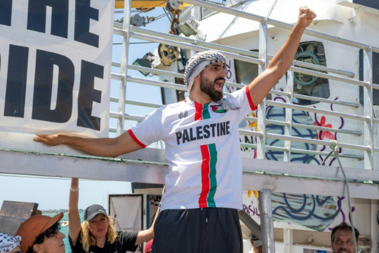 Un membre d'équipage du Handala, un nouveau bateau transportant des militants pro-palestiniens et de l'aide humanitaire à destination de Gaza, le 13 juillet 2025 à Syracuse, en Sicile ( AFP / Giovanni ISOLINO )