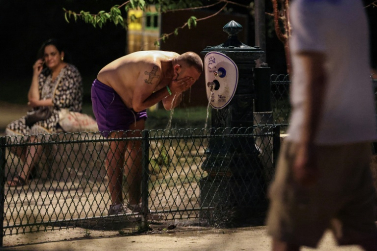 Un homme se rafraîchit à une fontaine publique près du Canal Saint-Martin à Paris en pleine canicule, le 25 juin 2026 ( AFP / Ludovic MARIN )