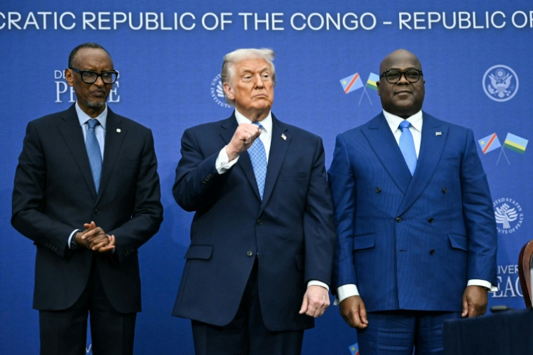 Le président américain Donald Trump entouré par les chefs d'Etat rwandais Paul Kagame (G) et congolais Etienne Tshisekedi (D) lors de la cérémonie de signature d'un accord de paix, à Washington le 4 décembre 2025 ( AFP / ANDREW CABALLERO-REYNOLDS )