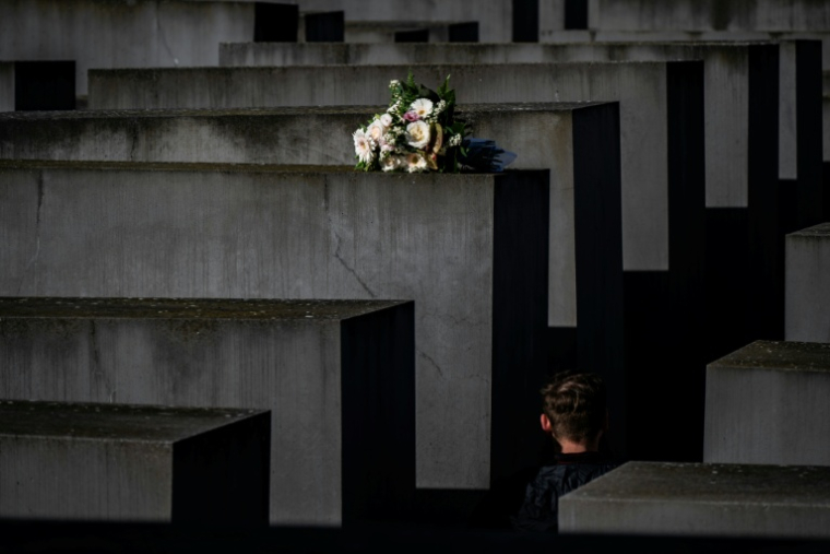 Une personne passe près d'un bouquet déposé sur une stèle du Mémorial de l'Holocauste à Berlin, le 30 septembre 2024 ( AFP / John MACDOUGALL )
