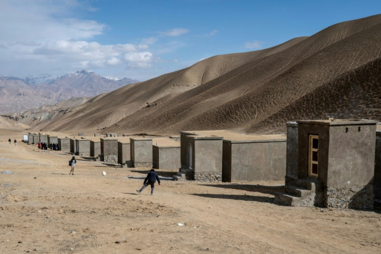 Des enfants jouent au football près des maisons nouvellement construites pour les Afghans rapatriés d'Iran et du Pakistan à Jar-e-Khushk, dans la banlieue de la province de Bamiyan, le 20 janvier 2026 ( AFP / Wakil KOHSAR )