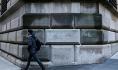 Un homme passe devant la pierre angulaire de la Banque fédérale de réserve de New York