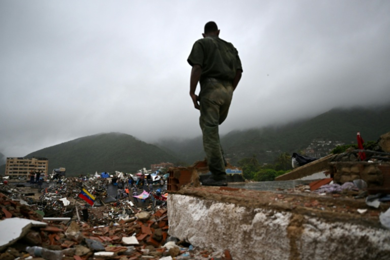 Un militaire vénézuélien devant des immeubles effondrés lors d'un double séisme à Caraballeda, au Venezuela, le 11 juillet 2026 ( AFP / Raul ARBOLEDA )