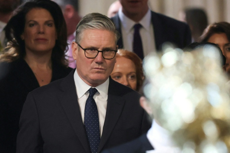 Le Premier ministre britannique Keir Starmer (c) retourne à la Chambre des communes après avoir écouté le discours du roi lors de l'ouverture solennelle du Parlement au palais de Westminster, le 13 mai 2026 à Londres ( POOL / Toby Melville )