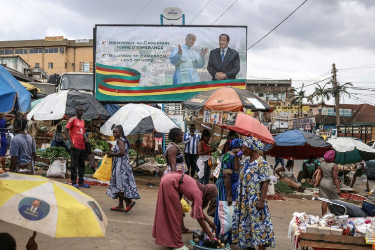Vue d'ensemble d'un panneau d'affichage montrant les portraits du pape Léon XIV (g) et du président camerounais Paul Biya (d), à Yaoundé, le 13 avril 2026, à la veille de la visite du pape au Cameroun ( AFP / Daniel Beloumou Olomo )