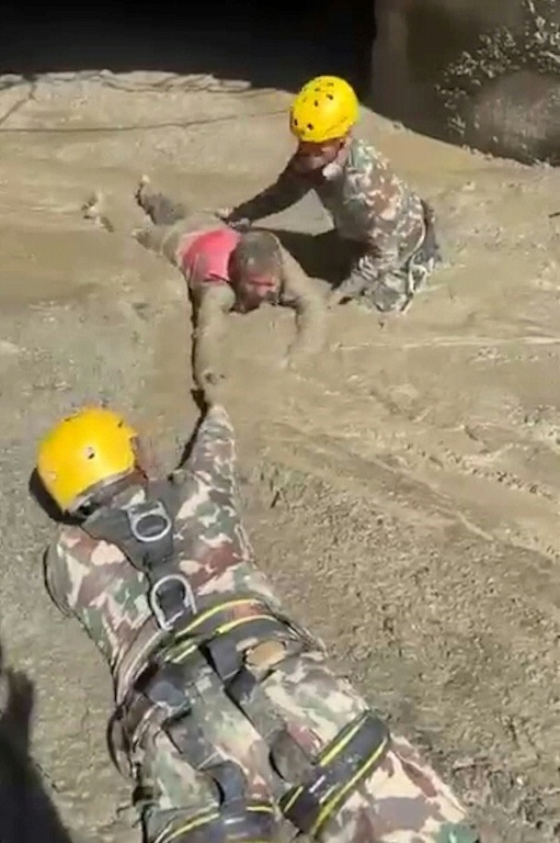 Cette capture d’écran, extraite d’une vidéo fournie par un vidéaste amateur et diffusée par le secrétariat du Premier ministre du Népal le 28 août 2026, montre l’Armée népalaise en train de secourir une personne coincée à l’intérieur d’un tunnel d’un projet hydroélectrique après la crue ( Prime Minister Secretariat, Nepal / - )