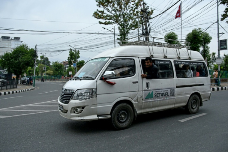 Des passagers à bord d'un minibus électrique, le 29 avril 2026 à Katmandou  ( AFP / Prakash MATHEMA )