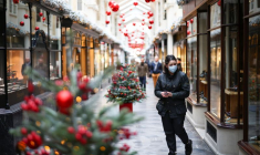 Woman walks through the Burlington Arcade adorned with Christmas decorations, in London