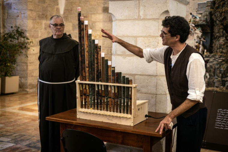 Le musicologue médiéval David Catalunya (d) donne un aperçu de l'histoire d'une réplique fonctionnelle contenant des tuyaux originaux du plus ancien orgue de la chrétienté, lors de la présentation de l'instrument au couvent Saint-Sauveur dans la Vieille ville de Jérusalem, le 9 septembre 2025 ( AFP / JOHN WESSELS )