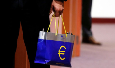 Un responsable tient un sac avec le logo de l'euro lors d'une réunion des ministres des Finances de la zone euro à Bruxelles