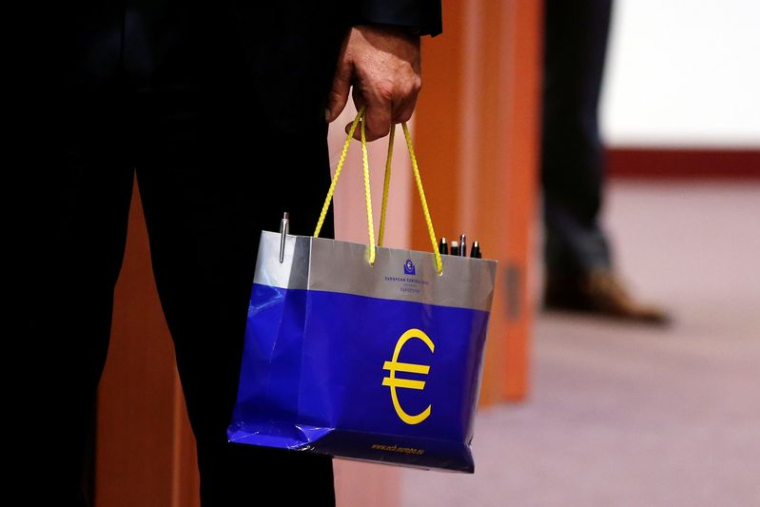 Un responsable tient un sac avec le logo de l'euro lors d'une réunion des ministres des Finances de la zone euro à Bruxelles