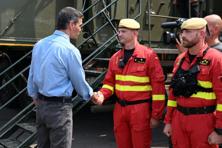 Photo remise par La Moncloa, la résidence du Premier ministre espagnol, montrant le chef du gouvernement Pedro Sánchez (gauche), serrant la main d’un pompier lors d’une visite au centre d’opérations de lutte contre l’incendie à La Vall d’Uixó, Castellón de la Plana, Valence, en Espagne, le 27 juillet 2026 ( LA MONCLOA / Borja Puig de la  Bellacasa )