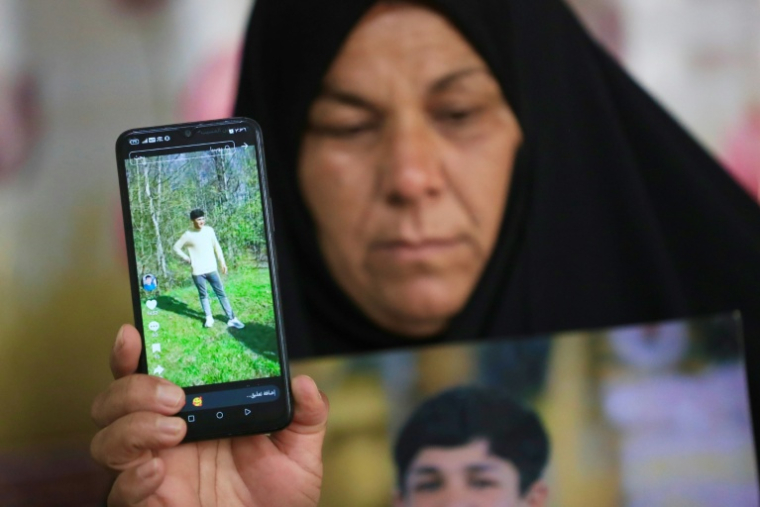 Zeinab Jabbar montre une photo de son fils Mohammed Imad, parti se battre dans l'armée russe en Ukraine, chez elle à Musayab, au sud de Bagdad, le 10 septembre 2025 en Irak ( AFP / Karrar Jabbar )