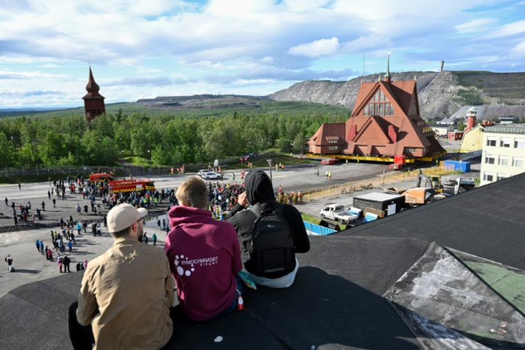 Des personnes assistent au déplacement de l'église en bois de Kiruna, le 19 août 2025 à Kiruna, en Suède ( TT NEWS AGENCY / Fredrik SANDBERG )