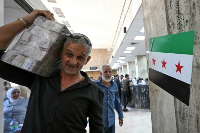 Un homme quitte la banque centrale de Damas avec des livres syriennes, le 21 mai 2025 ( AFP / LOUAI BESHARA )