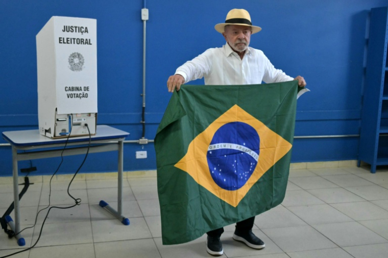 Le président brésilien de gauche, Luiz Inacio Lula da Silva, déploie le drapeau national dans le bureau où il vote au premier tour de la présidentielle à Sao Bernardo do Campo, dans l'Etat de Sao Paulo, le 4 octobre 2026   ( AFP / NELSON ALMEIDA )