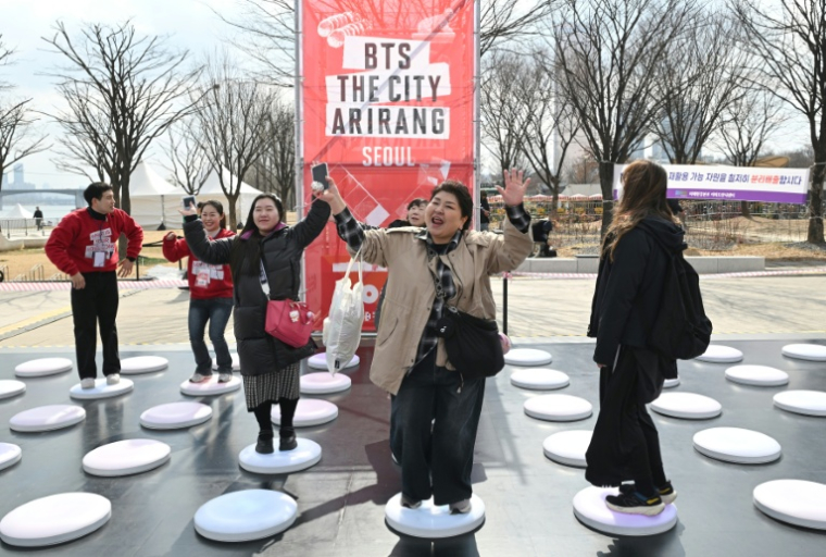 Des admiratrices de BTS s'amusent au niveau d'une fan-zone, le 20 mars 2026 à Séoul ( AFP / Jung Yeon-je )