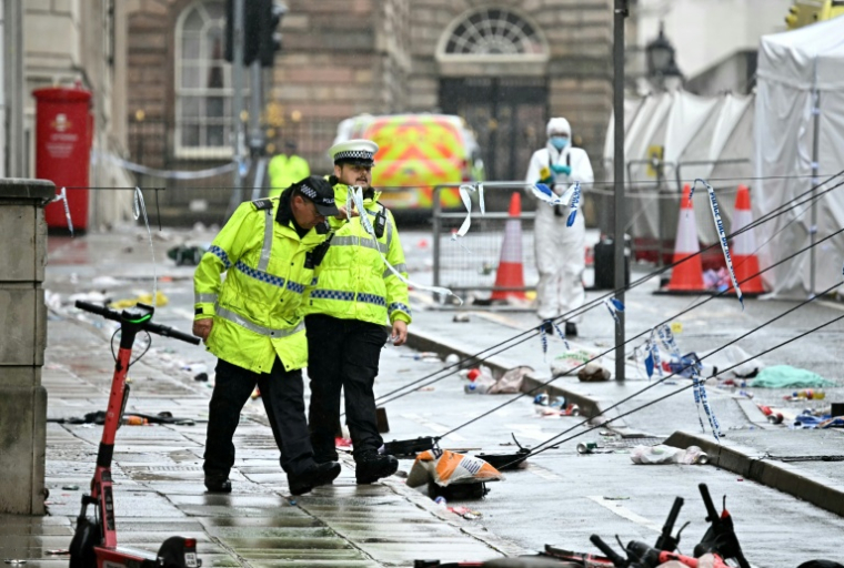 Des policiers sur les lieux où une voiture a foncé dans la foule lors de la parade de la victoire pour le trophée de la Premier League remporté club de football Liverpool FC, le 27 mai 2025 à Liverpool, dans le nord-ouest de l'Angleterre ( AFP / Paul ELLIS )