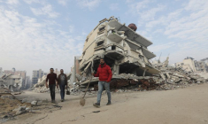 Des palestiniens marchent devant les décombres de bâtiments à Gaza