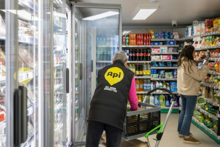Une employée de la société Api remplit les rayons d'une superette en libre-service sans caissier à Claix, le 1er décembre 2022 en Charente ( AFP / YOHAN BONNET )