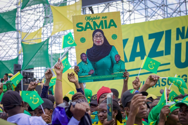 Des partisans de la présidente sortante et candidate à la présidentielle en Tanzanie Samia Suluhu Hassan brandissent son portrait lors d'un meeting à Dar es Salaam le 28 août 2025 ( AFP / Ericky Boniphace )
