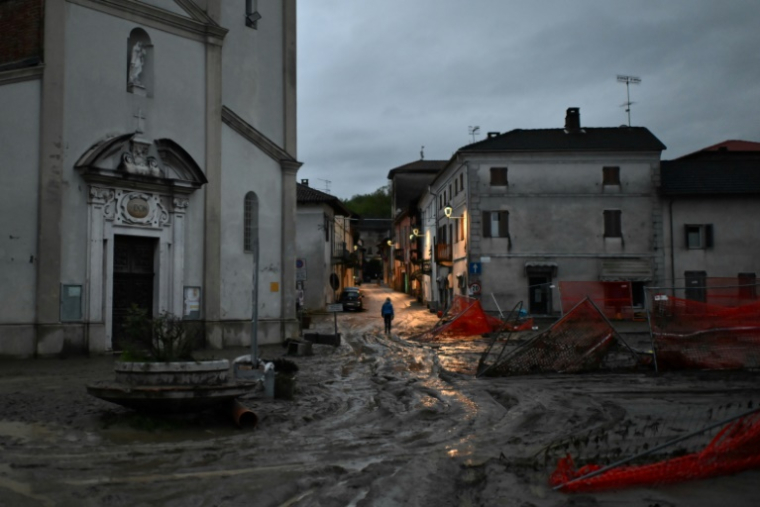 Un habitant dans les rues boueuses de Lauriano, à la suite de fortes intémpéries, le 17 avril 2025 dans le nord-ouest de l'Italie ( AFP / MARCO BERTORELLO )