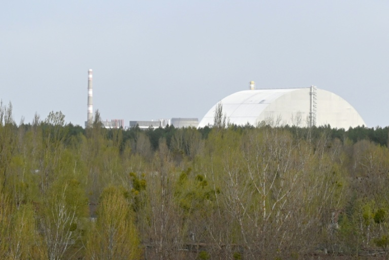 L'enceinte de confinement recouvrant le réacteur accidenté de la centrale nucléaire de Tchernobyl, vu depuis la ville fantôme de Pripyat, le 23 avril 2026, près de 40 ans après la catastrophe ( AFP / Sergei SUPINSKY )