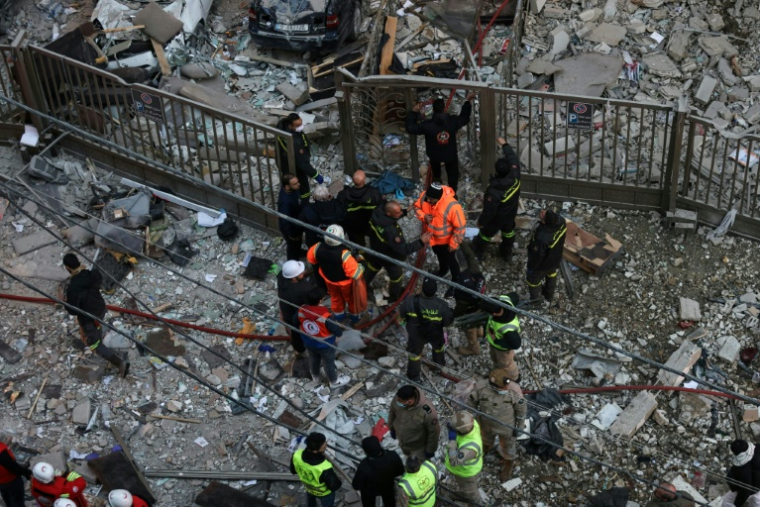 Des secouristes et des habitants sur le site d'une frappe aérienne israélienne dans le quartier d'Aïcha Bakkar à Beyrouth, le 11 mars 2026 au Liban ( AFP / IBRAHIM AMRO )