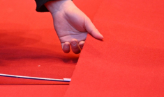 Une personne déroule le tapis rouge devant le Palais de la Berlinale, parmi les préparatifs pour le premier grand festival de cinéma de l'année en Europe, à Berlin, le 10 février 2026 ( AFP / RALF HIRSCHBERGER )
