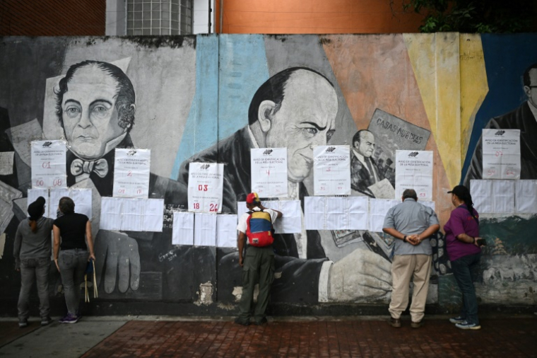 Des électeurs regardent les listes électorales devant un bureau de vote à Caracas, lors des élections pour élire députés et gouverneurs, le 25 mai 2025 au Venezuela ( AFP / Federico PARRA )