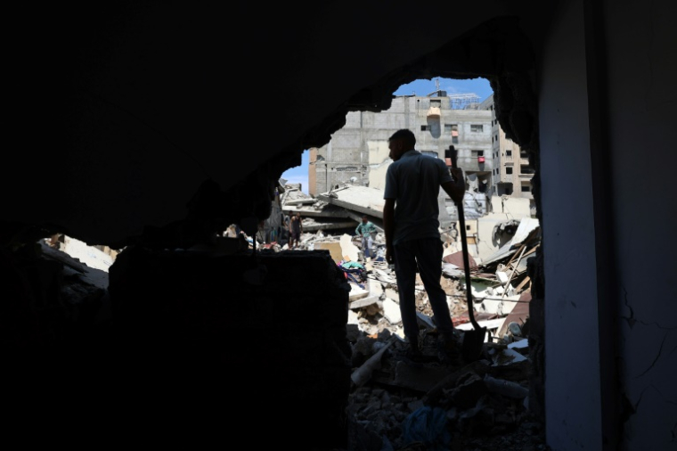 Un Palestinien dans les décombre d'un bâtiment détruit par une frappe israélienne au camp de réfugiés de Nousseirat, dans le centre de la bande de Gaza, le 4 mai 2025 ( AFP / Eyad BABA )