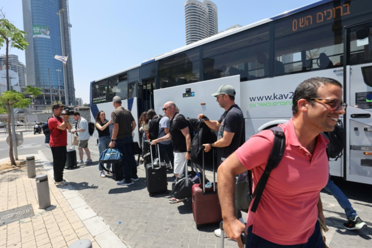 Des Israéliens descendent d'un bus après avoir été rapatriés en Israël lors d'un vol spécial, le 18 juin 2025 à Tel Aviv ( AFP / GIL COHEN-MAGEN )