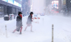 Des passants sur la 6e avenue en pleine tempête de neige à New York le 25 janvier 2026 ( AFP / CHARLY TRIBALLEAU )